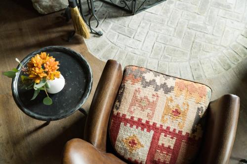 a table and a chair with a vase with a flower on it at Ancient Lore Village in Knoxville