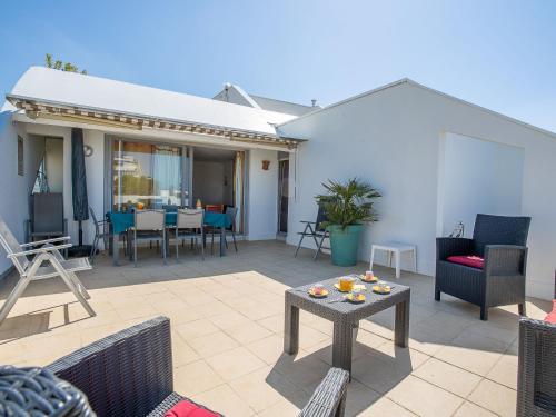 une terrasse avec des chaises et une table avec de la nourriture. dans l'établissement Apartment Cap Sud-3 by Interhome, à La Grande Motte