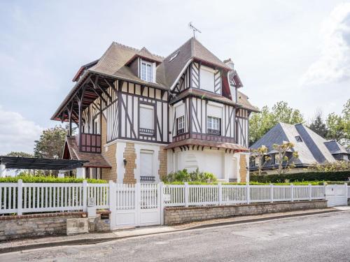 une maison avec une clôture blanche devant elle dans l'établissement Apartment La Pergola by Interhome, à Cabourg