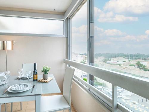 une salle à manger avec une table et une grande fenêtre dans l'établissement Apartment Les Trois Mâts-8 by Interhome, à Canet