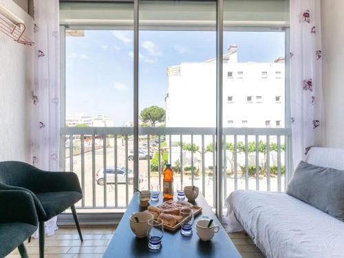 un salon avec une table et une grande fenêtre dans l'établissement Apartment Los Amigos-10 by Interhome, au Grau-du-Roi