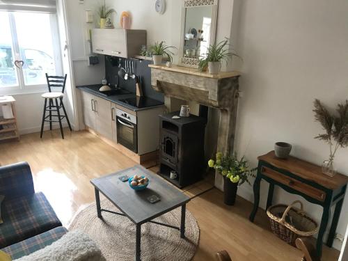 un salon avec une cheminée et une table dans l'établissement Charming 1-bed cottage Montemboeuf, à Montembœuf