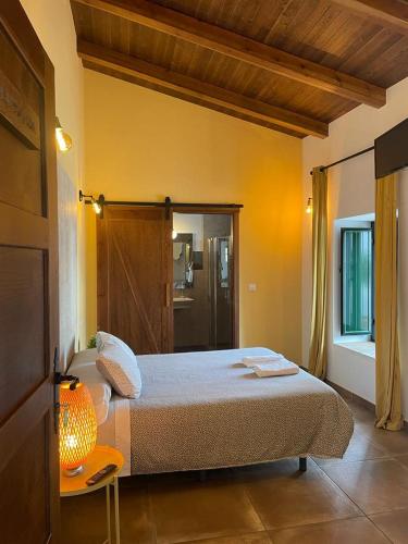 a bedroom with a bed and a table with a lamp at FINCA LAS DEHESILLAS in Monesterio