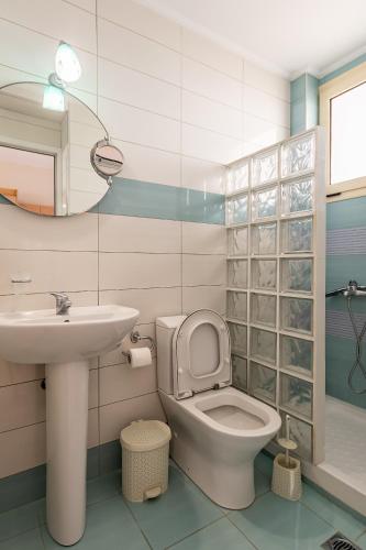 a bathroom with a sink toilet and a mirror at Pleasure Beach Hotel in Malia