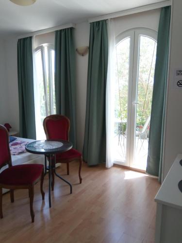 a living room with a table and chairs and a window at Ana Rooms in Krk