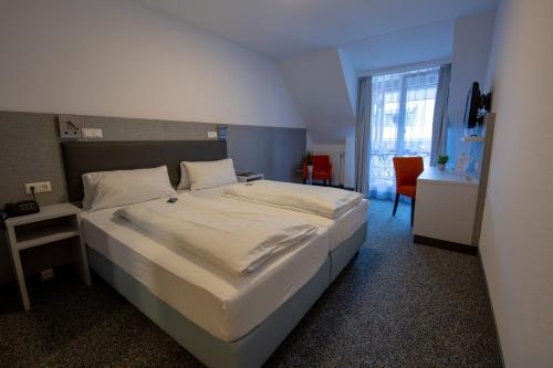 1 dormitorio con 1 cama grande y escritorio en Hotel Lamm, en Höchberg
