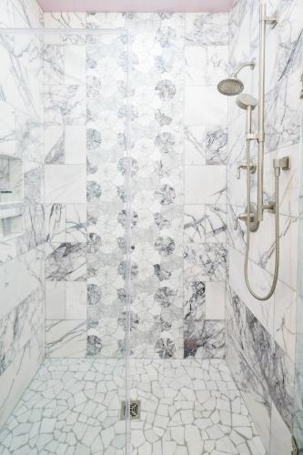 a bathroom with a shower with white tiles at Ancient Lore Village in Knoxville