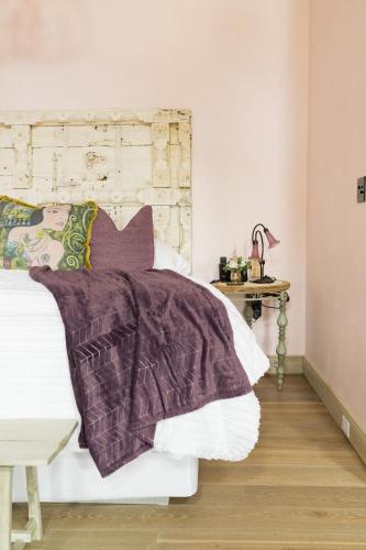 a bed with a purple blanket on top of it at Ancient Lore Village in Knoxville
