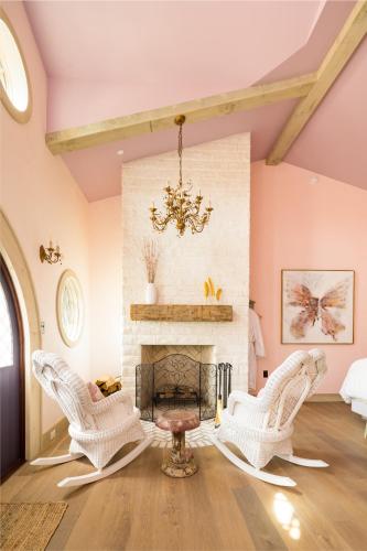 a living room with white chairs and a fireplace at Ancient Lore Village in Knoxville