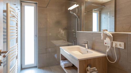 a bathroom with a sink and a mirror at UplandParcs Montafon in Sankt Gallenkirch