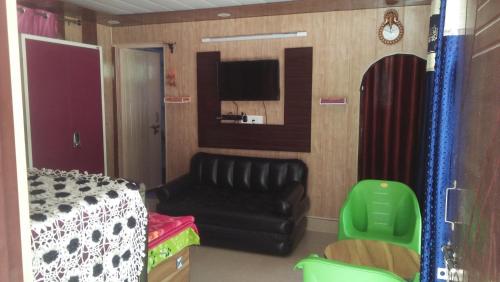 a living room with a couch and a tv at Ganga Lakshya Dham in Uttarkāshi