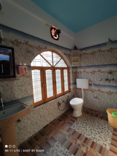 een badkamer met een toilet, een wastafel en een raam bij Ganga Lakshya Dham in Uttarkāshi
