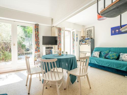 ein Wohnzimmer mit einem Tisch, Stühlen und einem Sofa in der Unterkunft Holiday Home Villas Plein Soleil 1 by Interhome in La Grande-Motte