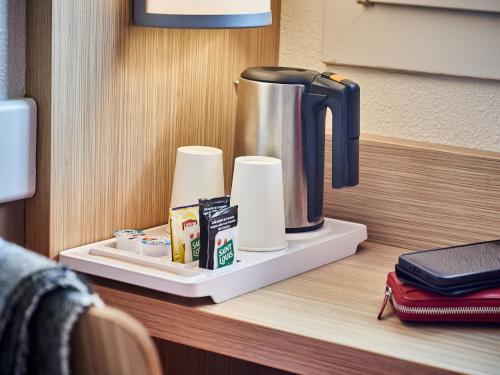 a coffee maker on a shelf in a hotel room at Kyriad Rouen Sud - Val de Reuil in Val de Reuil