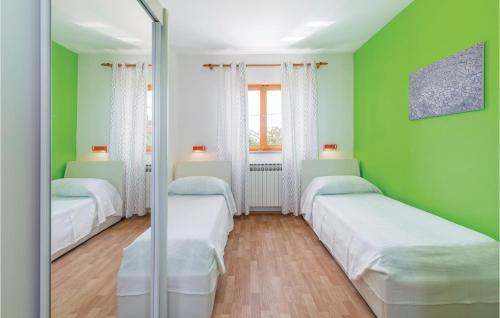 a green room with three beds and a window at 7 Bedroom Nice Home In Labin in Labin