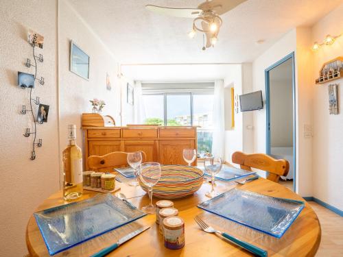 - une table à manger avec des verres et des bouteilles de vin dans l'établissement Apartment Terrasses de la Baronnie-4 by Interhome, au Grau-du-Roi