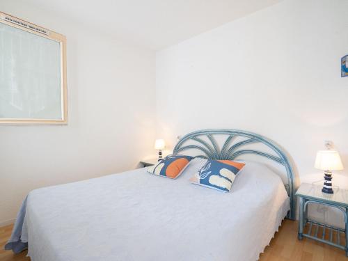 - une chambre avec un lit blanc et des oreillers dans l'établissement Apartment Terrasses de la Baronnie-4 by Interhome, au Grau-du-Roi
