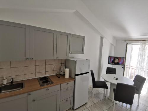 a kitchen with a white refrigerator and a table at Apartman Katarina Promajna in Promajna
