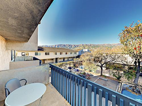 a balcony with a table and chairs and a view at Hale I'a in Carpinteria