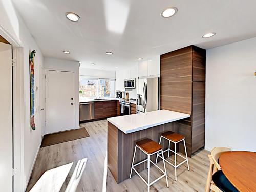 a kitchen with a counter and a table and chairs at Hale I'a in Carpinteria