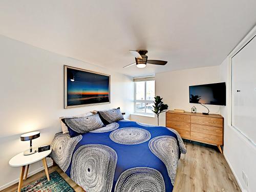 a bedroom with a blue bed and a ceiling fan at Hale I'a in Carpinteria