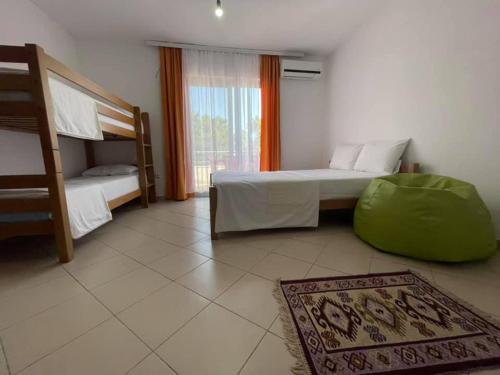 a bedroom with two bunk beds and a rug at Aparthotel Vila Tufi in Velipojë