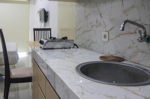 雅加達的住宿－RedLiving Apartemen Paradise Mansion - Gunawan，厨房柜台配有水槽和烤面包机