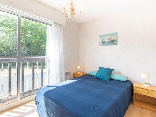 une chambre avec un lit bleu et une grande fenêtre dans l'établissement Apartment Résidence du Port-2 by Interhome, à Cabourg