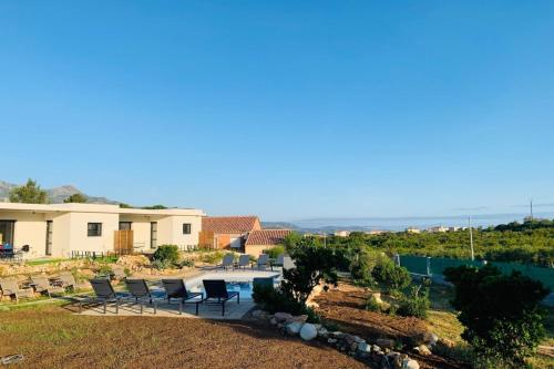 una casa con sillas y una piscina en appart Libeccio swimming pool bbq, en Calenzana