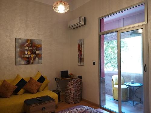 a living room with a yellow couch and a sliding glass door at Ryan S1et Ryan S2 in Fès
