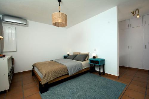 a bedroom with a bed and a blue table at 205 Casa Cactus in Sagres