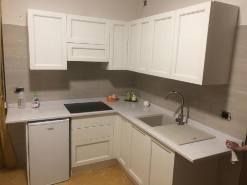 a kitchen with white cabinets and a sink at B&B Il Sogno in Montescaglioso