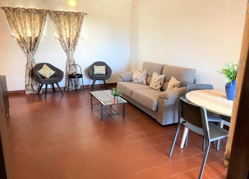 un salon avec un canapé, une table et des chaises dans l'établissement Apartamento vista mar e pôr do Sol (1,6km Praia), à Aljezur