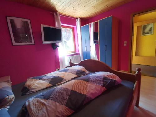 a bedroom with a bed and a tv on the wall at Ferienwohnung Sabine in Hornberg
