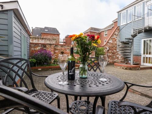 a table with a bottle of wine and flowers on it at Park Mews in Weymouth