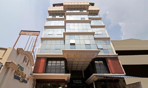 wysoki budynek z mnóstwem okien w obiekcie Treebo Trend Surya Yatri Niwas w mieście Belagavi