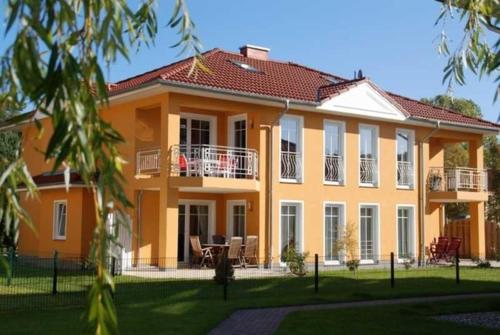 a large orange house with a lawn in front of it at Fewo Ostseetraum_JAeHN in Ostseebad Karlshagen