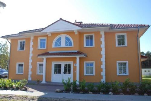 a large orange house with white windows at Fewo Ostseetraum_JAeHN in Ostseebad Karlshagen