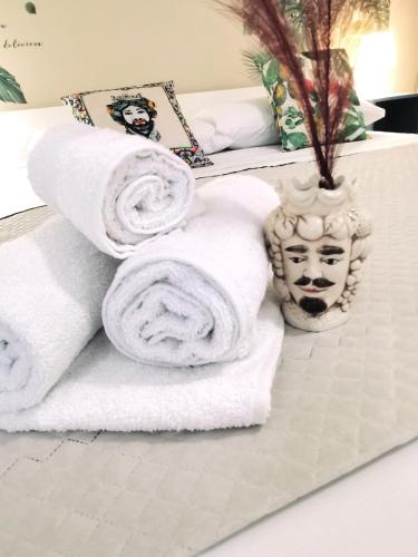 a pile of towels sitting on top of a bed at A due passi dal centro Sweet Rooms in Agrigento