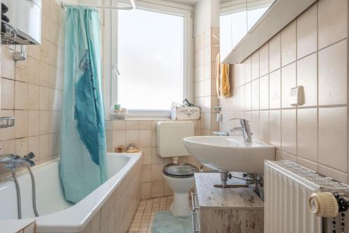 ein Badezimmer mit einer Badewanne, einem Waschbecken und einem WC in der Unterkunft Private Apartment in Hannover