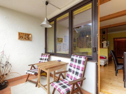 um pátio com 2 cadeiras e uma mesa de madeira em Apartment Holiday-6 by Interhome em Zell am See