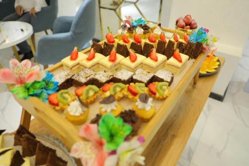 een tafel met een uitstalling van verschillende soorten desserts bij Porto Bello Hotel in Tasjkent