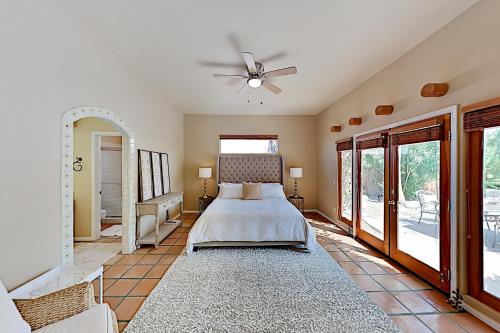 een slaapkamer met een bed en een plafondventilator bij Avenida Velasco Escape in La Quinta