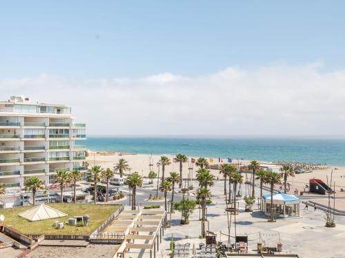 - une vue sur une plage bordée de palmiers et un bâtiment dans l'établissement Apartment Copacabana-28 by Interhome, à Canet