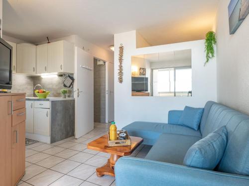 un salon avec un canapé bleu et une cuisine dans l'établissement Apartment Copacabana-28 by Interhome, à Canet