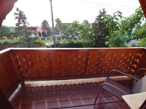 a porch with two chairs and a fence at Zöld sziget Apartmanház in Gyenesdiás