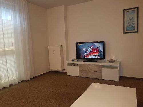 オストゼーバート・カールスハーゲンにあるFewo Ostseeperle 04_KADOのリビングルーム(薄型テレビ、テーブル付)