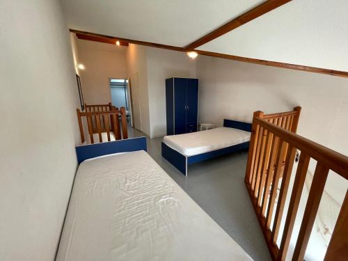 - une petite chambre avec 2 lits et un escalier dans l'établissement Le Tournesol, à Mimizan