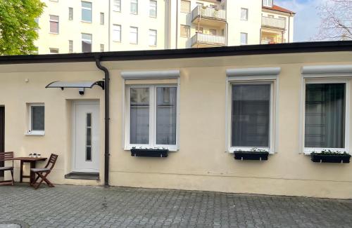 a white building with windows and a table with a chair at 2Raum-Apartment Leznew in Leipzig