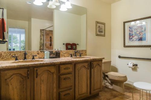 a bathroom with a sink and a toilet and a mirror at Oak Tree Manor Permit# 259,056 in La Quinta